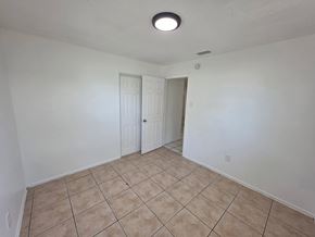 Fort Myers apartment for rent - A room with a tiled floor and two doors.
