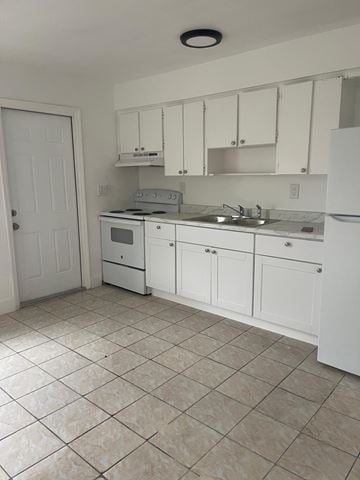 Fort Myers apartment for rent - A kitchen with white cabinets and appliances.