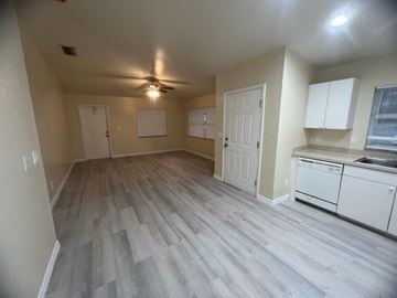 Lehigh Acres apartment for rent - A room with a ceiling fan and light, and a kitchenette with a sink and dishwasher.