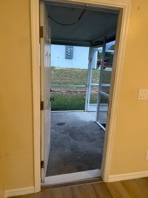 Lehigh Acres apartment for rent - A doorway opens to a patio with a view of a grassy area and a house.
