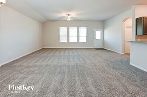 Beaumont house for rent - an empty living room with carpet and a kitchen