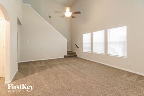 Splendora house for rent - A spacious room with a staircase and a ceiling fan.