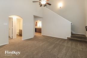 Splendora house for rent - A spacious room with a carpeted floor and a staircase leading to another room.