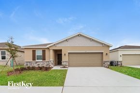 Bartow house for rent - a beige house with a garage door and grass