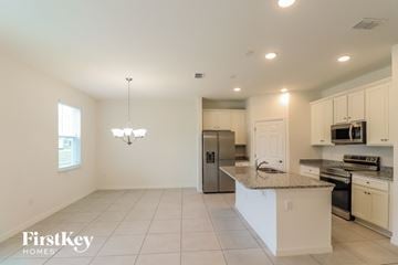 Bartow house for rent - a kitchen with white cabinets and a granite counter top