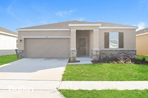 Bartow house for rent - a beige house with a driveway and a garage door