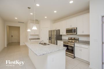 Bartow house for rent - a kitchen with white cabinets and a marble counter top