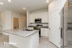 Bartow house for rent - A kitchen with granite countertops and white cabinets.