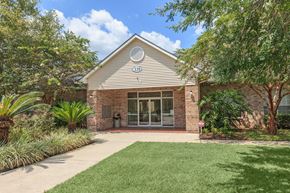 Thibodaux townhouse for rent - the front of a brick house with a lawn and trees