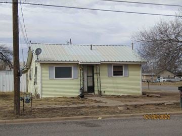 Levelland house for rent - front view of a yellow house with a metal roof