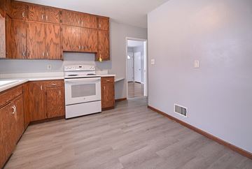 Grand Forks house for rent - A kitchen with wooden cabinets and a white oven.