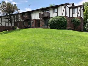 Crystal Lake apartment for rent - A grassy area in front of a building with a balcony.