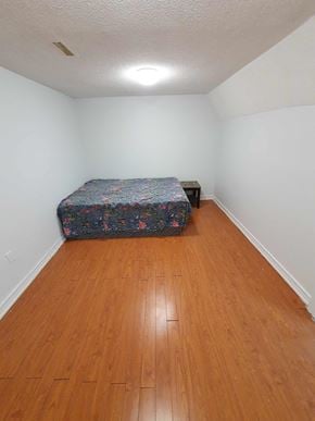 Toronto house for rent - a bedroom with a bed and a wooden floor