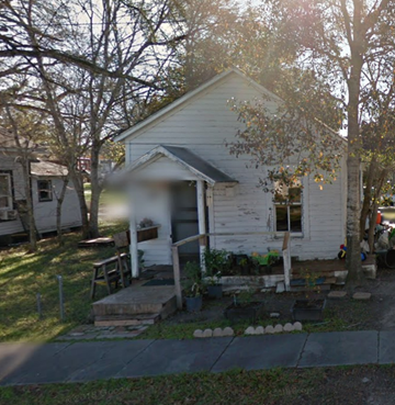 El Campo house for rent - A small white house with a porch and a tree in front.