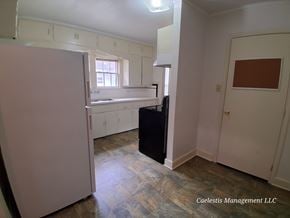 Bay City house for rent - A room with a white door, a window, and a black trash can.