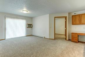 Moorhead apartment for rent - A room with a desk and a window with blinds.