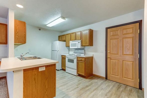 Moorhead apartment for rent - A kitchen with wooden cabinets and a white countertop.