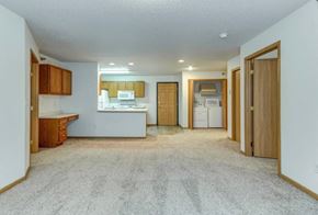 Moorhead apartment for rent - A kitchen area with a counter, cabinets, and a fridge.