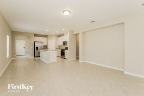 Yulee house for rent - an empty living room with a kitchen and a sink
