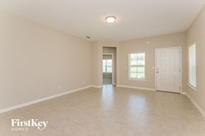 Yulee house for rent - an empty living room with a white door and tile flooring