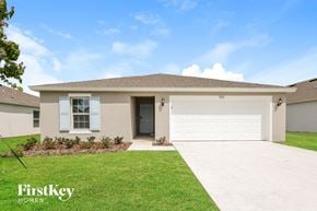 Winter Haven house for rent - a beige house with a garage door and a lawn
