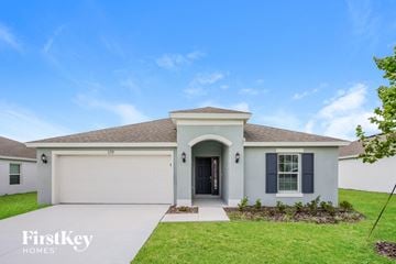 Winter Haven house for rent - a white house with a garage door and a driveway