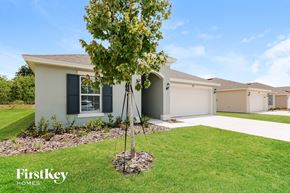 Winter Haven house for rent - A tree stands in front of a house with the words "FirstKey Homes" on the bottom left.