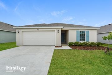 Winter Haven house for rent - a white house with a garage door and a lawn