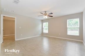 Winter Haven house for rent - an empty living room with a ceiling fan and tiled floors