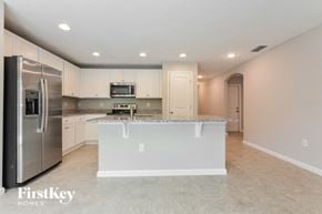 Winter Haven house for rent - a white kitchen with a large island and stainless steel appliances