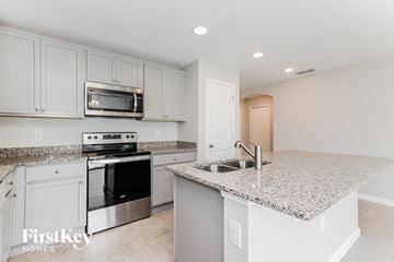 Winter Haven house for rent - a kitchen with white cabinets and granite counter tops and a sink