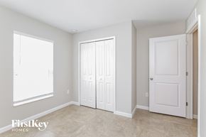 Winter Haven house for rent - a master bedroom with two closets and a door and a window