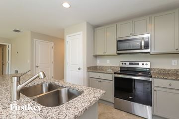 Winter Haven house for rent - a kitchen with granite counter tops and white cabinets