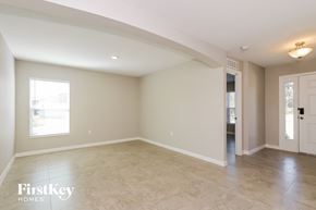 Winter Haven house for rent - A spacious empty room with a door on the right side.