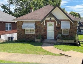 St Louis house for rent - A small brick house with a white door and windows.