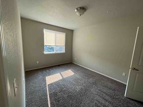 Boise apartment for rent - an empty room with gray carpet and a window