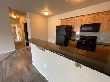 Boise apartment for rent - a kitchen with a long counter and a black refrigerator