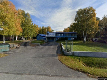 Anchorage apartment for rent - A blue building is surrounded by trees with autumn leaves.