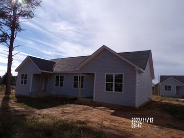 Franklinton apartment for rent - A small house with a grey roof and white walls is shown in the image.