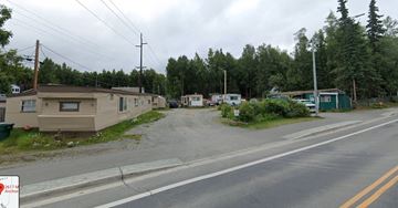 Anchorage apartment for rent - A street view of a residential area with houses and trees.