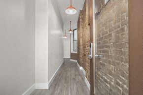 New York apartment for rent - a long hallway with a brick wall and wooden doors