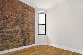 New York apartment for rent - an empty room with a brick wall and a window