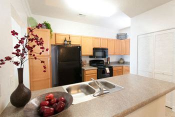 Open kitchens include black appliances, built-in microwave, bistro bar & pantry