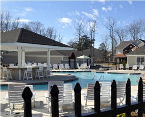 Newport News condo for rent - a swimming pool with chairs and tables around it