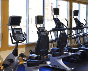 Newport News condo for rent - a group of exercise equipment in a gym with windows