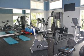 Bradenton house for rent - a gym with a lot of exercise equipment and windows
