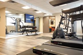 Norwalk apartment for rent - a gym with cardio equipment and a tv in a room