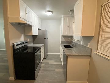Merced house for rent - A kitchen with black appliances and beige cabinets.