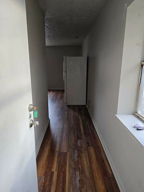 Ashland apartment for rent - A long hallway with wood floors and white walls.