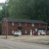 Ashland apartment for rent - A red brick building with a white door and a black awning.